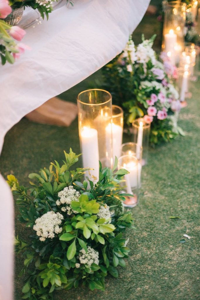 A beautifully decorated wedding aisle with candles and floral arrangements creating a romantic ambience.